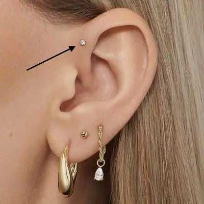 close up of blonde person with high lobe piercing