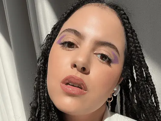 woman with clear skin standing near window