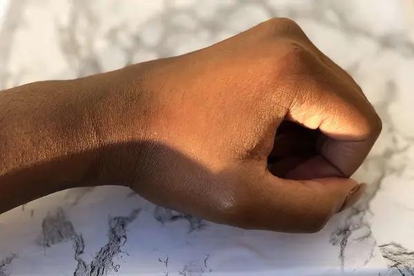Closeup of hand resting on marble countertop
