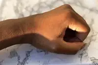 Closeup of hand resting on marble countertop