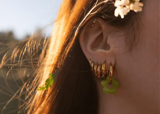 ear of woman with six gold hoop earrings in ear