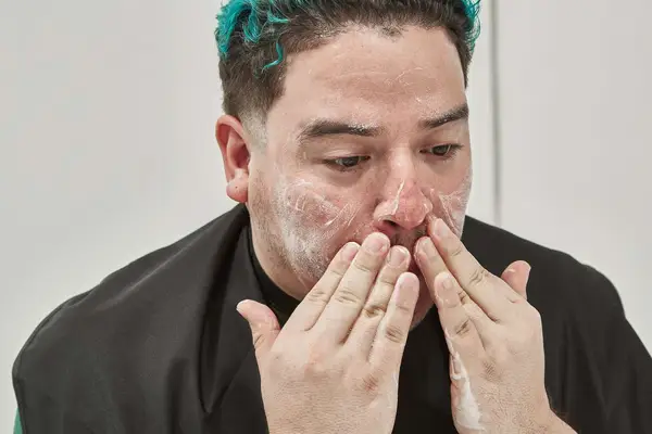 Person washing their face with cleanser