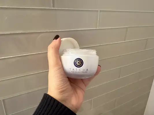 person holding Tatcha The Silk Cream against a tile background