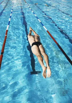 Waxed man in speedo diving into a pool