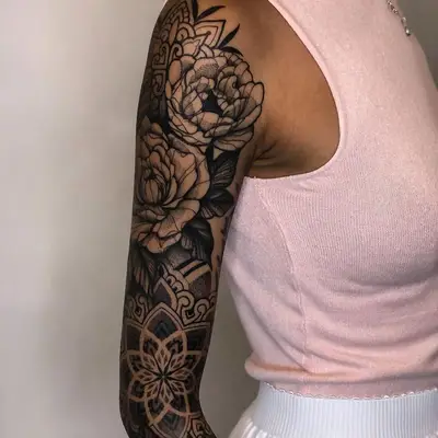 Person with a full sleeve tattoo with mandalas and flowers