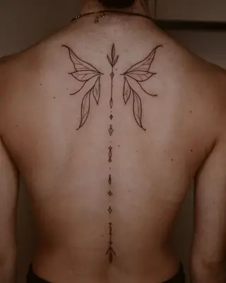 Person with a mandala-inspired fairy wing back tattoo