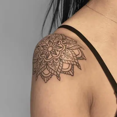 Person with a black mandala tattoo on the shoulder