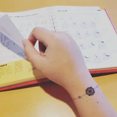 Person with a small dreamcatcher mandala tattoo on the wrist