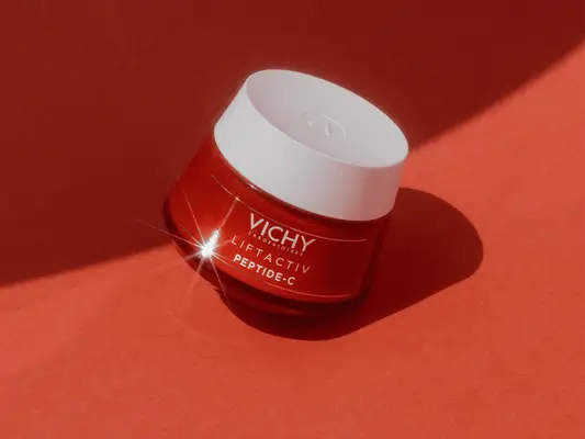 jar of polypeptide moisturizer on orange background