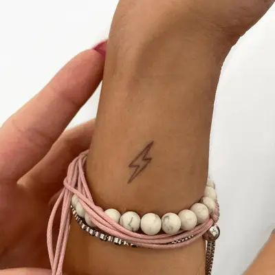 Person with a dotted bird wrist tattoo