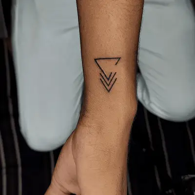 Person with a back triangle wrist tattoo