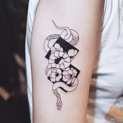 Black diamonds, snake, and flowers Negative Space Tattoo