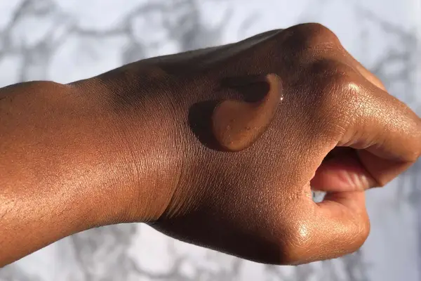 A person with soapy hands using a body wash for dry skin and two sets of hands pumping out body wash