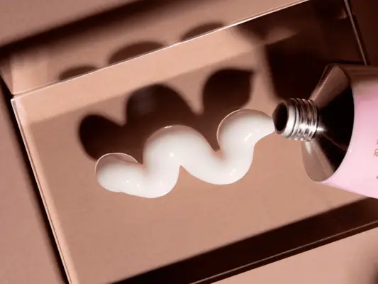 squiggle of skincare product texture on tan background