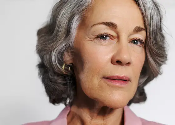 woman with crows feet smiling at camera