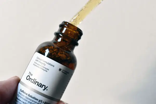 Dropper being lifted out of the The Ordinary Caffeine Solution 5% + EGCG bottle