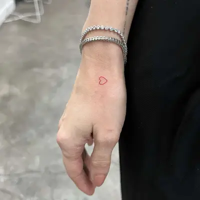 small red heart tattoo on woman