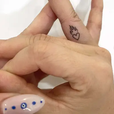 heart with flames on top finger tattoo