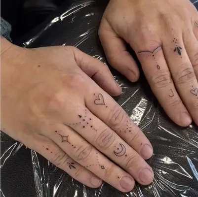 set of hands covered in small finger tattoos