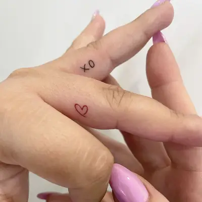 small heart tattoo on inside of finger on woman