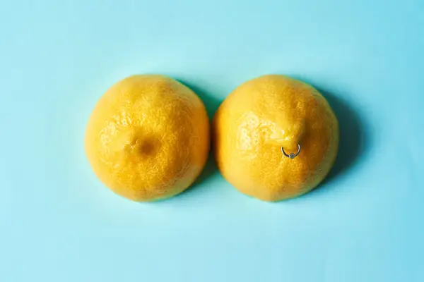 Lemons pierced to look like nipples on a blue background