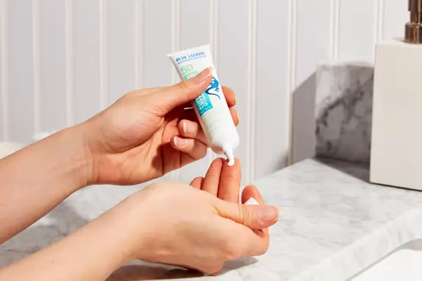 Person dabbing Blue Lizard Sensitive Face Mineral Sunscreen SPF 30 onto finger