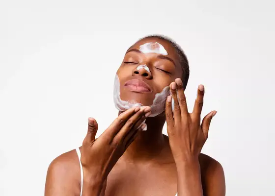 close up of woman washing face against white background