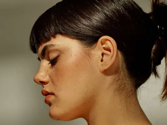 Profile view of a woman, her skin bright and even
