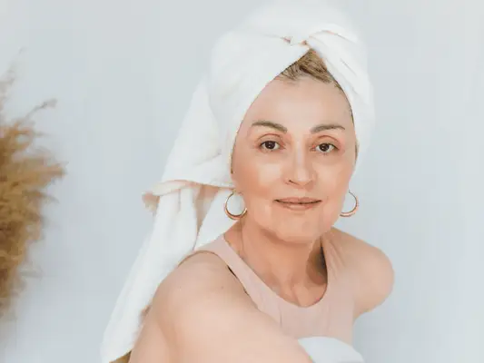 Close up of a woman with her hair wrapped in a towel and smooth skin