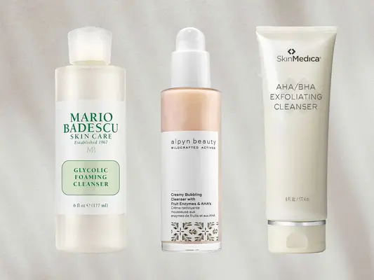 Three glycolic acid cleansers on a beige background, including Mario Badescu Glycolic Foaming Cleanser