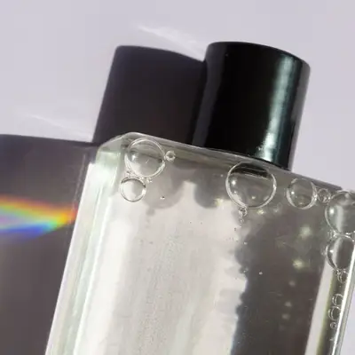 Bottle with black cap and clear liquid with bubbles