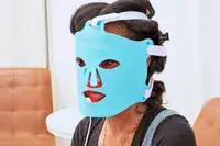 A person wears the HigherDOSE Red Light Face Mask
