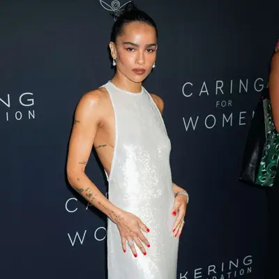 Zoë Kravitz at Kering Caring for Women Dinner in white dress showing off tattoos