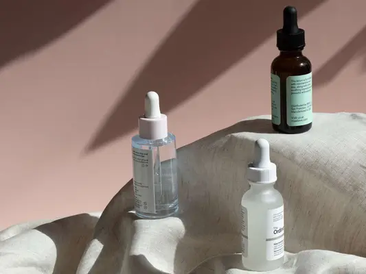 A trio of serums standing on a linen cloth