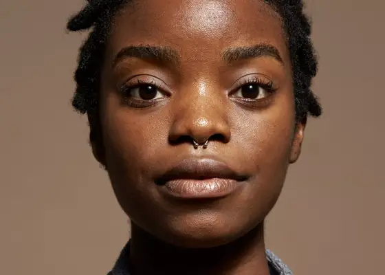 close up of woman with clear skin and septum piercing