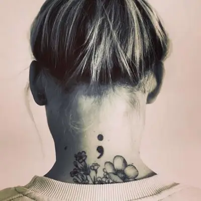 Back of neck with semicolon and flowers tattoos