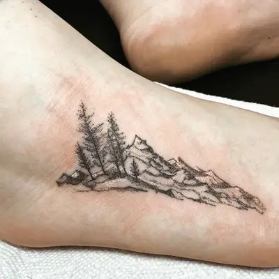 dotwork tattoo of a mountain and forest