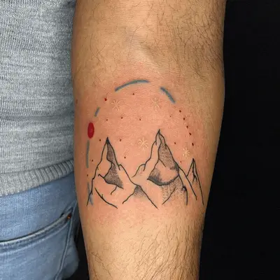 mountains tattoo with red and blue graphic over top