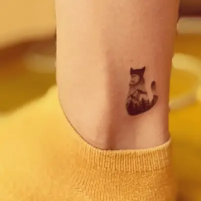 negative space mountain tattoo in the shape of a cat