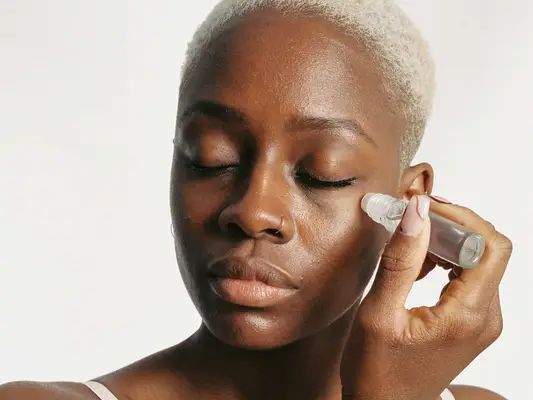 woman applying under eye serum
