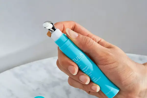 A person holds the TULA Eye Renewal Serum