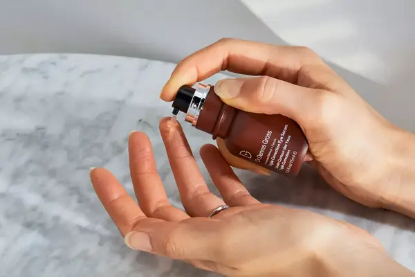 A person squeezes Dr. Dennis Gross Advanced Retinol + Ferulic Triple Correction Eye Serum onto their finger