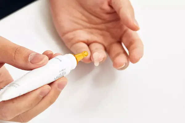 A person applies Dermalogica Biolumin-C Vitamin C Eye Serum to their finger