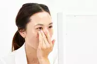 A person applies Dermalogica Biolumin-C Vitamin C Eye Serum