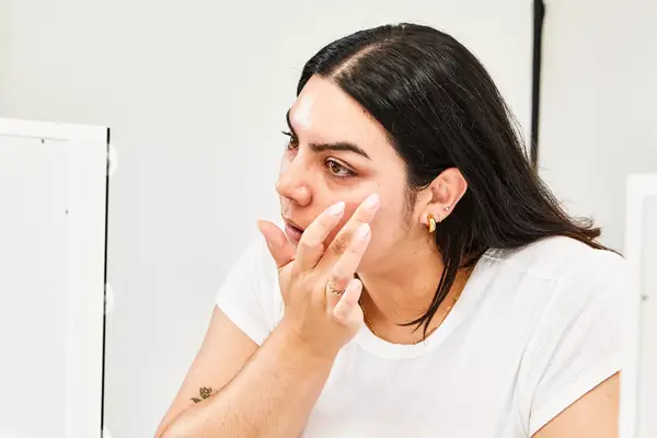 A person applies Environ Skin EssentiA Antioxidant & Peptide Eye Gel under their eye. 