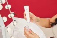 A person removes the cap on a tube of Beauty of Joseon Revive Eye Serum
