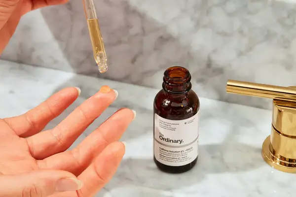 The Ordinary Caffeine 5% + ECGC Depuffing Eye Serum being dropped onto a finger
