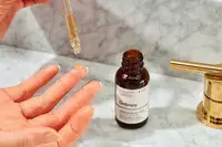 The Ordinary Caffeine 5% + ECGC Depuffing Eye Serum being dropped onto a finger