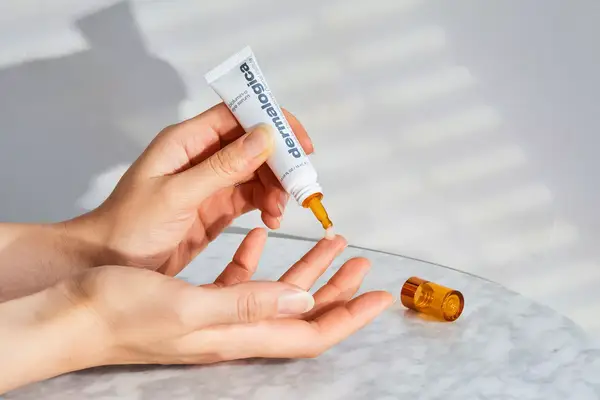 Hands applying Dermalogica Eye Serum to fingers