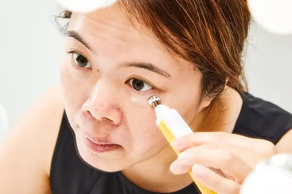 A person applies StriVectin Peptight 360 Tightening Eye Serum